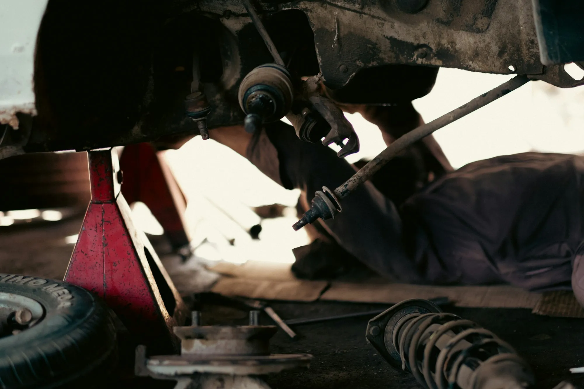 Mechaniker arbeitet unter einem angehobenen Fahrzeug