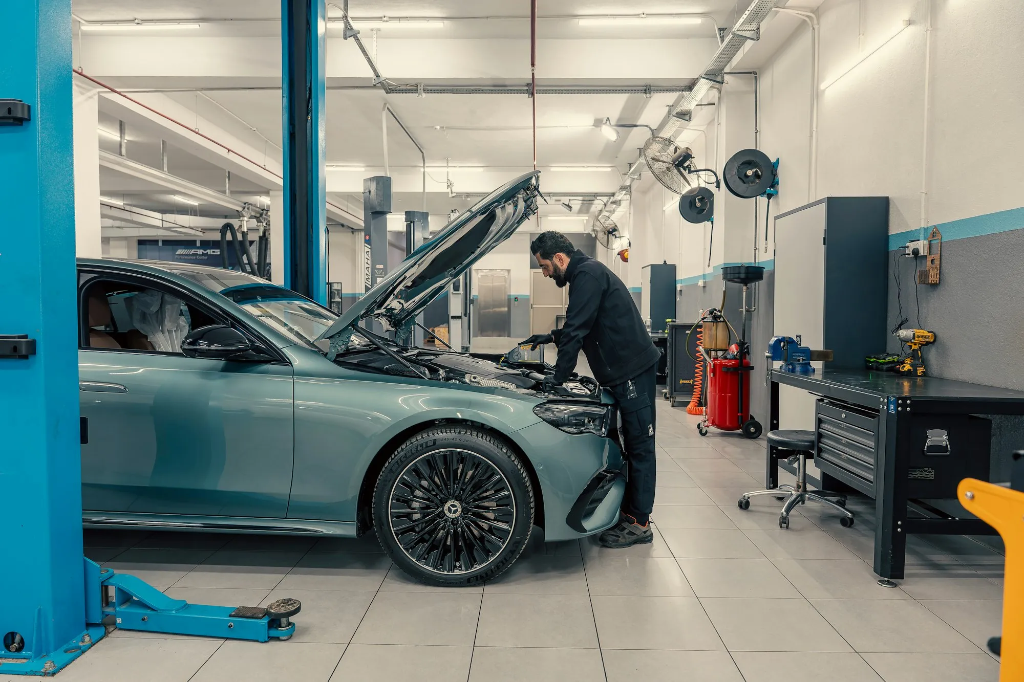 Helle Werkstatt mit Auto auf der Hebebühne