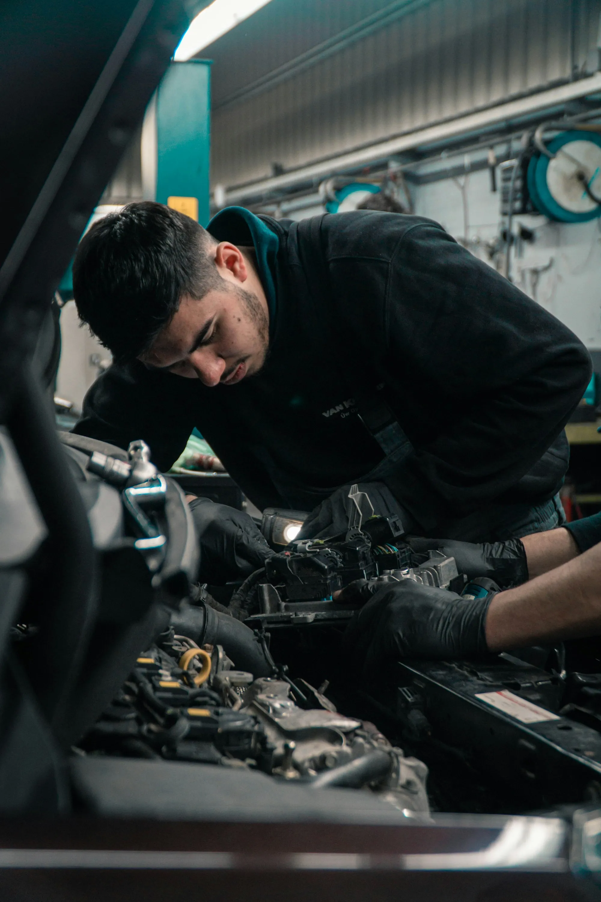 Mechaniker arbeitet konzentriert im Motorraum eines Autos